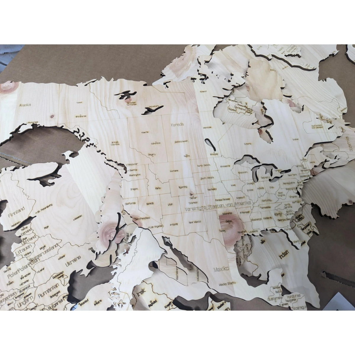 Detailansicht einer 3D-Weltkarte aus Zirbenholz mit gelaserten Ländern und Grenzen