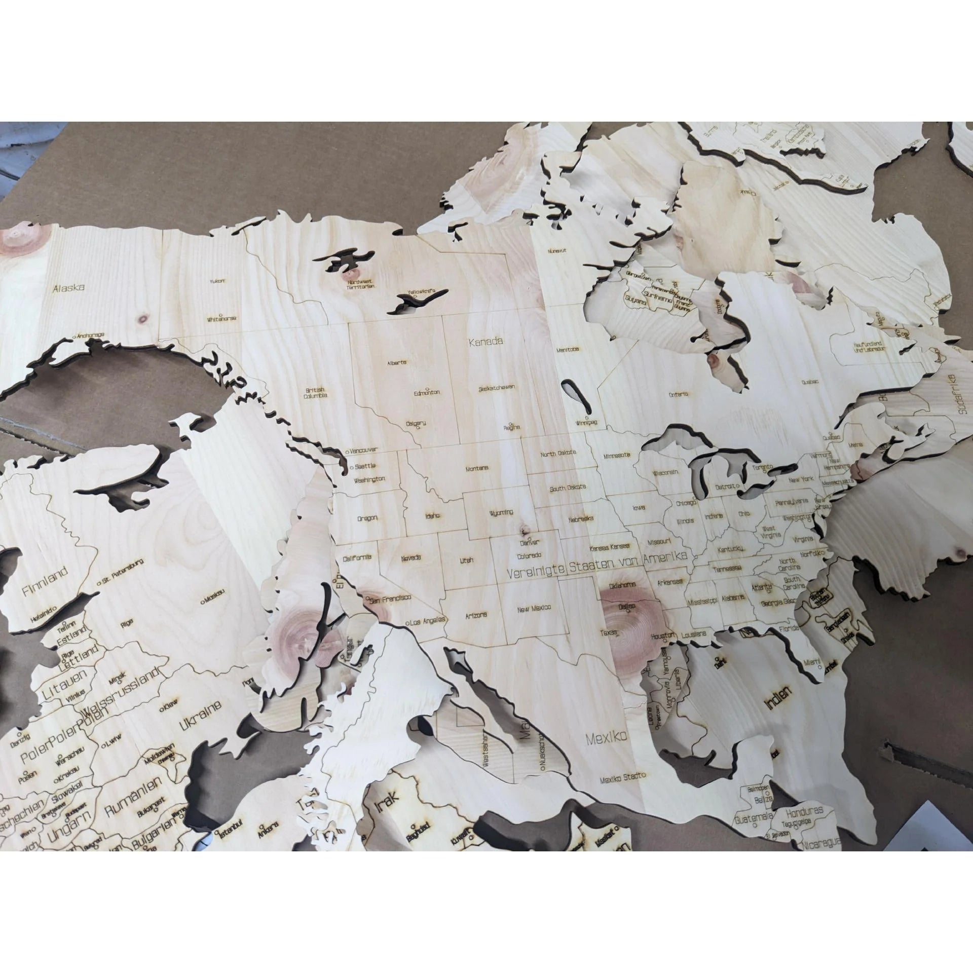 Detailansicht einer 3D-Weltkarte aus Zirbenholz mit gelaserten Ländern und Grenzen